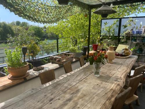 ノジャン・シュル・マルヌにあるVilla Victorineの木製テーブルと椅子付きのデッキから眺めの良い景色を望めます。