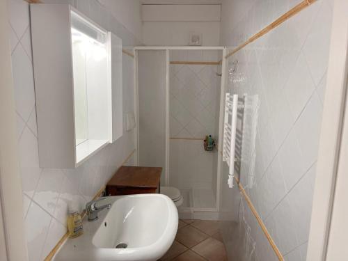 une salle de bain blanche avec un lavabo et des toilettes dans l'établissement Appartement Thomaïa, à Calvi