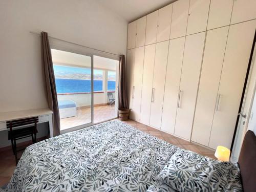 une chambre avec un lit et une vue sur l'océan dans l'établissement Appartement Thomaïa, à Calvi