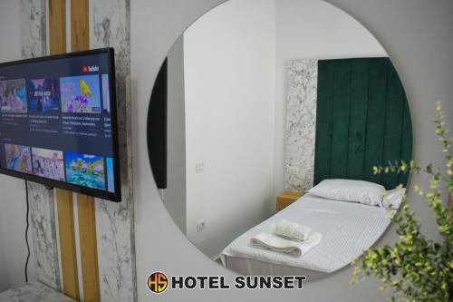 um espelho num quarto com uma cama e uma televisão em Hotel SUNSET Shengjin em Shëngjin