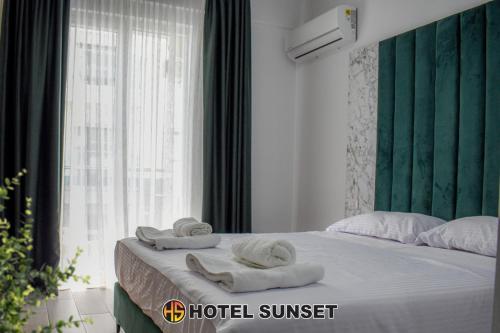 uma cama com toalhas e uma janela em Hotel SUNSET Shengjin em Shëngjin