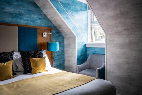 una camera con letto e parete blu di Duisdale House Hotel a Isleornsay
