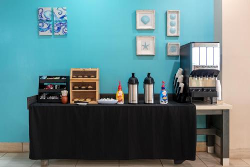 a black table with bottles of wine on a blue wall at Wyndham Corpus Christi Resort North Padre Island in Corpus Christi