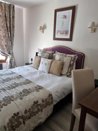 a bedroom with a bed and a table and a chair at Logis Hôtel-Restaurant Le Relais in Hauterives