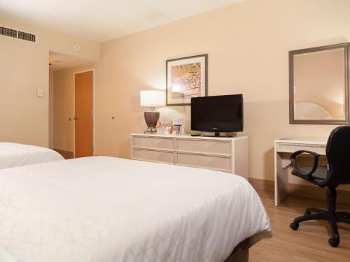 a hotel room with two beds and a desk and a television at Holiday Inn Express Torreon by IHG in Torreón