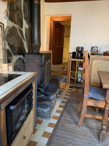eine Küche mit Steinofen und Holzboden in der Unterkunft Le Gîte du Rocher - Auzat in Auzat