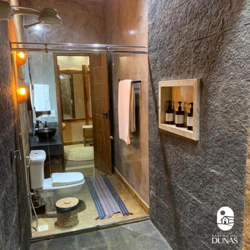 a bathroom with a shower with a toilet and a sink at Hotel Pousada Rancho das Dunas in Santo Amaro