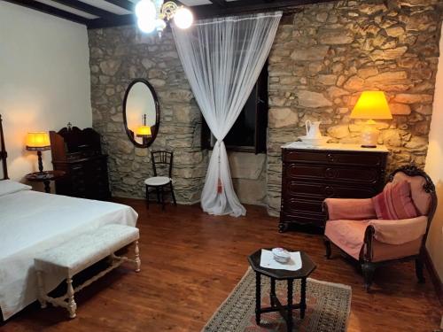 - une chambre avec un lit et un mur en pierre dans l'établissement Palacio de Cantiz, à Becerreá