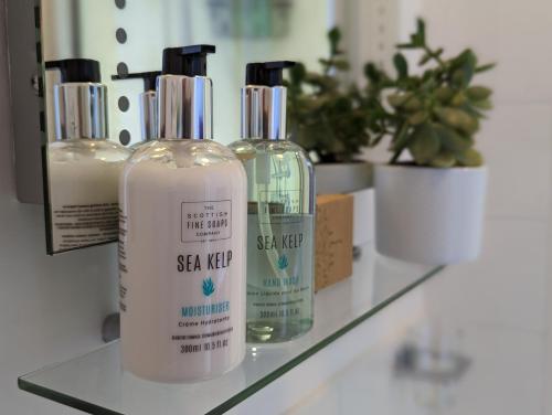 three bottles of skin care products sitting on a counter at Villa Marina in Torquay