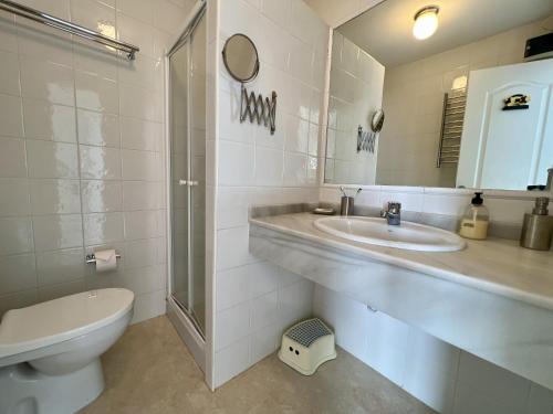 a bathroom with a sink and a toilet and a mirror at El Faro in La Herradura