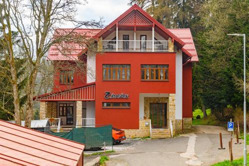 a red house with a red roof at Penzion Zámeček in Janske Lazne