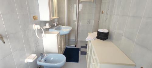 Un baño blanco con lavabo e inodoro. en Ai Grisi, en Cavalese