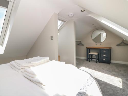 a attic bedroom with a bed and a mirror at Bwthyn Cae'r Efail in Bodewryd