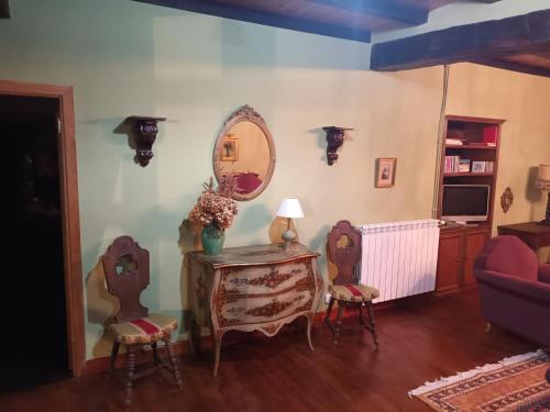 a living room with a table and chairs and a mirror at Palacio de Cantiz "Reserva de Ancares" in Becerreá