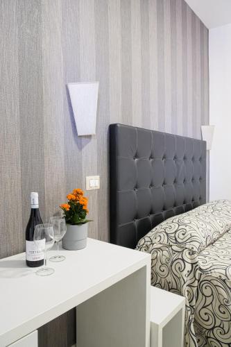 a bedroom with a bed and a table with a bottle of wine at Hotel Terrazza Magenta in Rome
