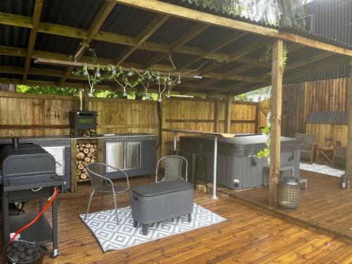 an outdoor deck with a grill and a grill at Lynbrook Haybarn, Hot tub and outdoor kitchen, New Forest in Ringwood