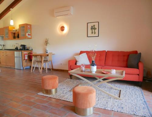 a living room with a red couch and a table at Serra Vida - A Place Of Presence in Santo António das Areias