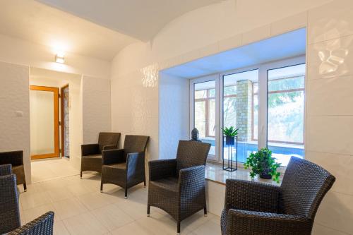 a waiting room with chairs and a table and windows at Penzion Zámeček in Janske Lazne