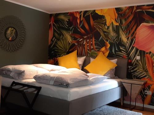 a bed with yellow pillows in a room with a mural at Apartments Am Spitalthor in Straubing
