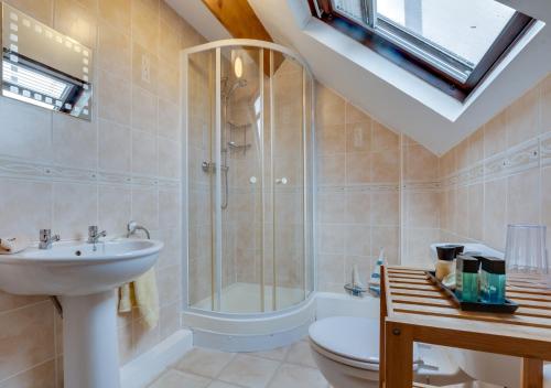 a bathroom with a shower and a sink and a toilet at Smugglers Cove Cottage in Ravenscar