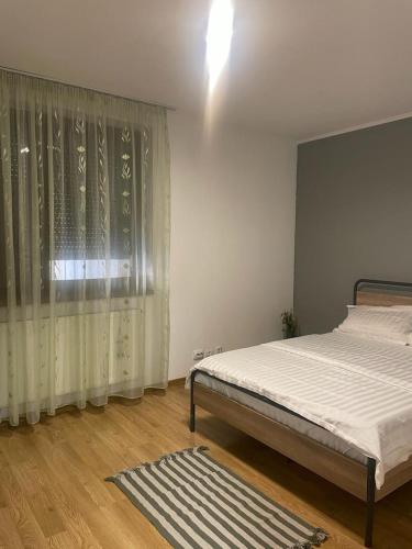 um quarto com uma cama e uma janela com cortinas em Zimbrului Apartment em Bistrita