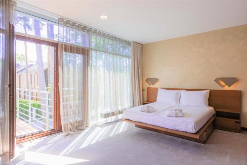 a bedroom with a bed and a large window at NEW Rixwell Collection Seaside Hotel Jurmala in Jūrmala