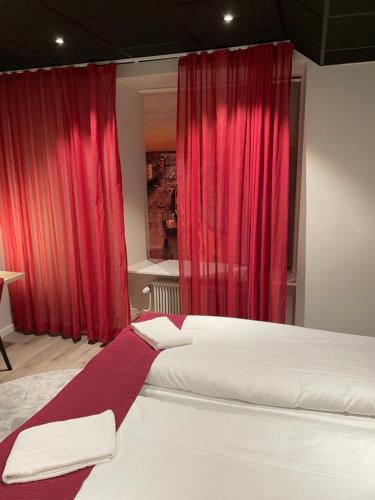 a bedroom with red curtains and a large bed at Dream - Luxury Hostel in Helsingborg