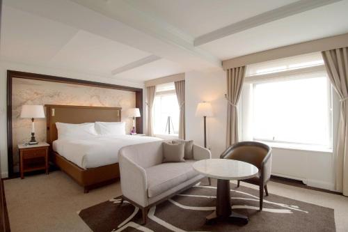 a hotel room with a bed and a couch and a chair at The Ritz-Carlton New York, Central Park in New York