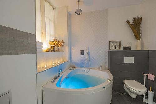 a bathroom with a blue tub and a toilet at Le petit Claude Bernard - studio cosy Bellecour in Lyon