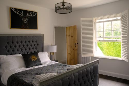 a bedroom with a large bed and a window at Woodnesborough Cottages in Eastry