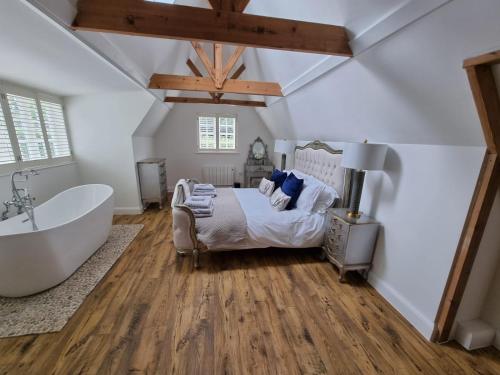a bedroom with a large bed and a bath tub at Woodnesborough Cottages in Eastry
