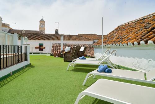um pátio com mesas brancas e cadeiras num telhado em Orange Square Rooftop Apartment 250 m2 em Marbella