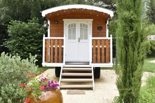 a wooden outhouse with a white door in a garden at Logis Hôtel-Restaurant Le Relais in Hauterives