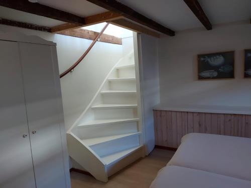 a bedroom with a staircase with a bed in it at Hotel Steeds aan Zee in Katwijk