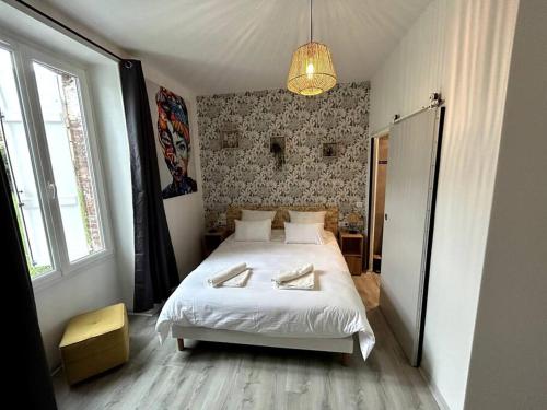Un dormitorio con una cama con dos toallas encima. en Bienvenue au Quai 27, en Épernay
