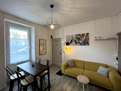 un salon avec un canapé vert et une table dans l'établissement Bienvenue au Quai 27, à Épernay