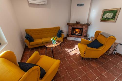 a living room with yellow couches and a fireplace at Entire house in the center of Ljubljana - FREE PARKING - Dragon Garden Pavilion Ljubljana in Ljubljana