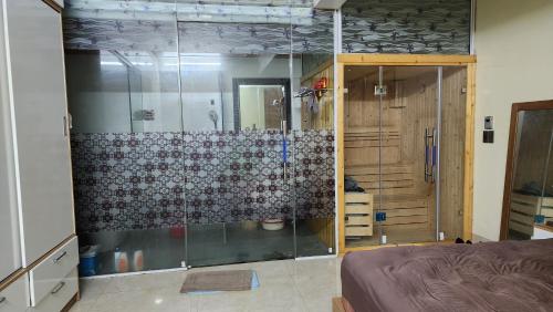 a bathroom with a shower with a glass door at Mộc House (Green House) 