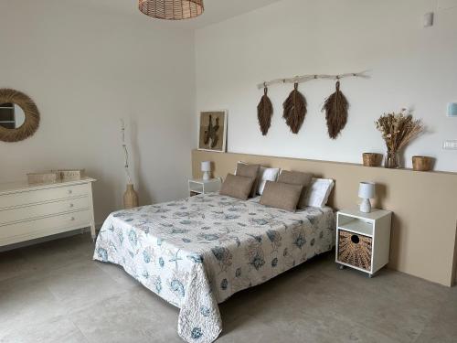 a bedroom with a bed and a white wall with feathers on it at Villa Antonia sul mare con piscina Torre a mare (Bari) in Bari