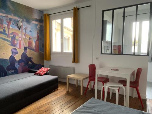 Studio perfect for 2 adults and 1 kid, and up to 2 kids - Jourdain 20e, 25mn to Louvre via line M11 في باريس: غرفة نوم بسرير وطاولة وكراسي