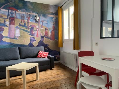 uma sala de estar com um sofá e uma pintura na parede em Studio perfect for 2 adults and 1 kid, and up to 2 kids - Jourdain 20e, 25mn to Louvre via line M11 em Paris