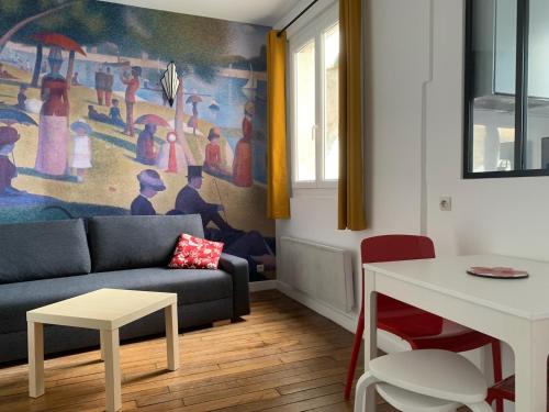 a living room with a couch and a painting on the wall at Studio perfect for 2 adults and 1 kid, and up to 2 kids - Jourdain 20e, 25mn to Louvre via line M11 in Paris