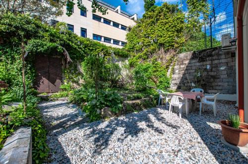 a garden with a table and chairs in front of a building at Entire house in the center of Ljubljana - FREE PARKING - Dragon Garden Pavilion Ljubljana in Ljubljana