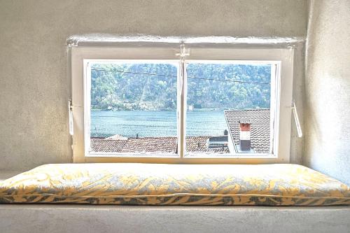 a window with a bed in front of it with a view at Casa Angiolina - Holidays in Morcote