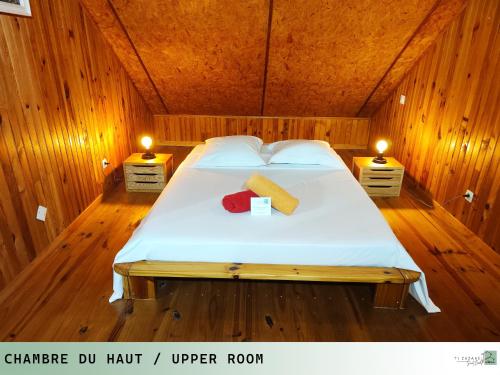 a bedroom with a bed in a wooden room at TI ZAZAKEL in Saint-Denis