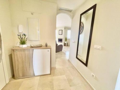 ein Wohnzimmer mit einem Wandspiegel in der Unterkunft The Gaff in the Sun in Manilva