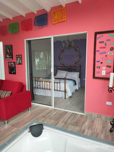 a living room with a bed and a red couch at Romántico refugio en la montaña in Copacabana