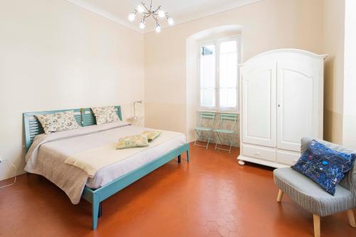 1 dormitorio con 1 cama y 1 silla en 166 - Casa Mosaico, La Spezia vicino al centro città, en La Spezia