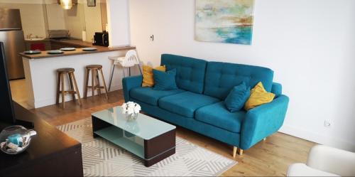 ein Wohnzimmer mit einem blauen Sofa und einer Küche in der Unterkunft Summer Nest Onix in Năvodari