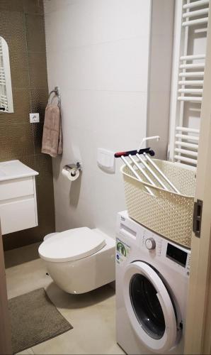 ein Badezimmer mit einem WC und einer Waschmaschine in der Unterkunft Summer Nest Onix in Năvodari